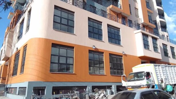 Un edificio de varios pisos con balcones y grandes ventanales.
