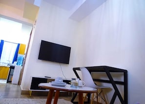 Suite studio Deluxe, vue sur la ville | Aire de séjour | Téléviseur connecté de 24 po avec télévision numérique