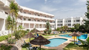 A hotel with multiple balconies, a swimming pool, and sun loungers. - Palm Beige Apartment, Vilamoura, Algarve (Quarteira)