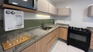 Een moderne keuken met een ingebouwde magnetron, oven en gasfornuis.