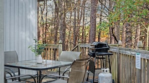 A covered outdoor patio with a table and chairs, a grill, and a gas cylinder. - Mohegan by Avantstay Private Dock + Firepit Community Pool + Beach (Long Pond)