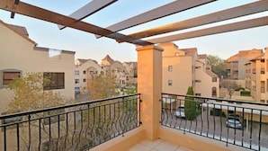 A balcony with a view of neighboring apartment buildings.