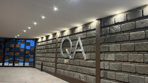 Un intérieur moderne avec un mur en pierre et un grand panneau portant l'inscription « QA ».