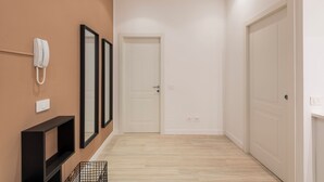 A hallway with a white door, a telephone, and a black shelf. - CORSO GARIBALDI 64 - LIVING MILAN (Milan)