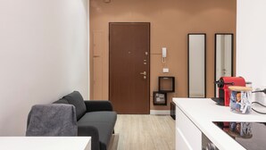 A modern living room with a sofa, a coffee machine, and a small table with a jar of snacks. - CORSO GARIBALDI 64 - LIVING MILAN (Milan)