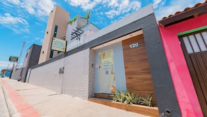 Un bâtiment moderne, avec une enseigne indiquant « Praia Studios » et le numéro « 120 » sur la porte.
