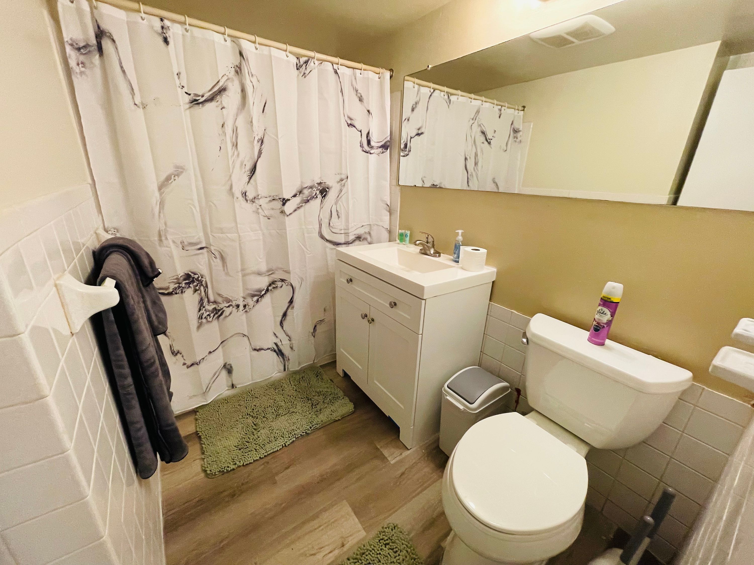 A bathroom with a toilet, sink, and shower curtain.