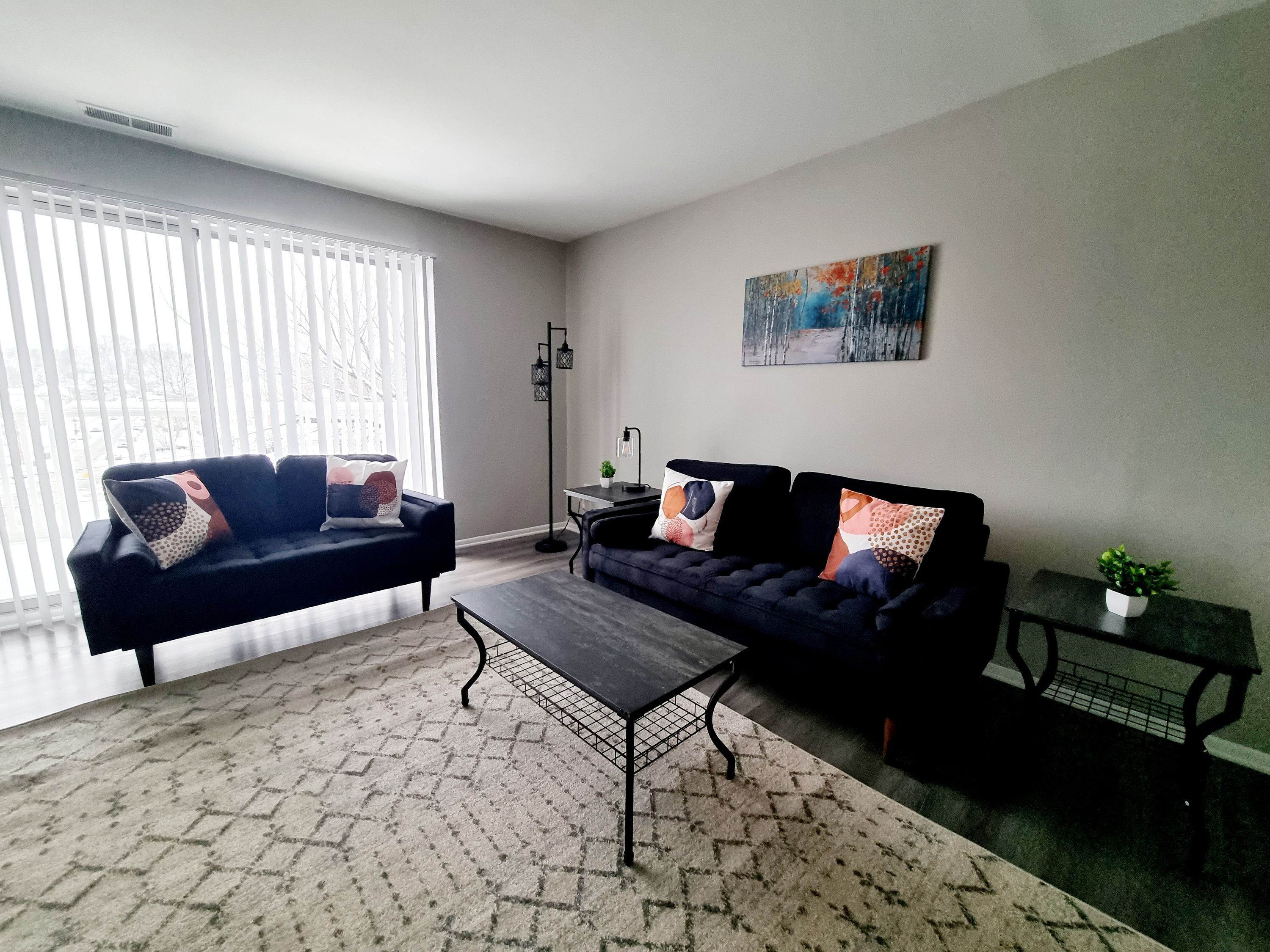 A modern living room with two sofas, a coffee table, and a small side table.
