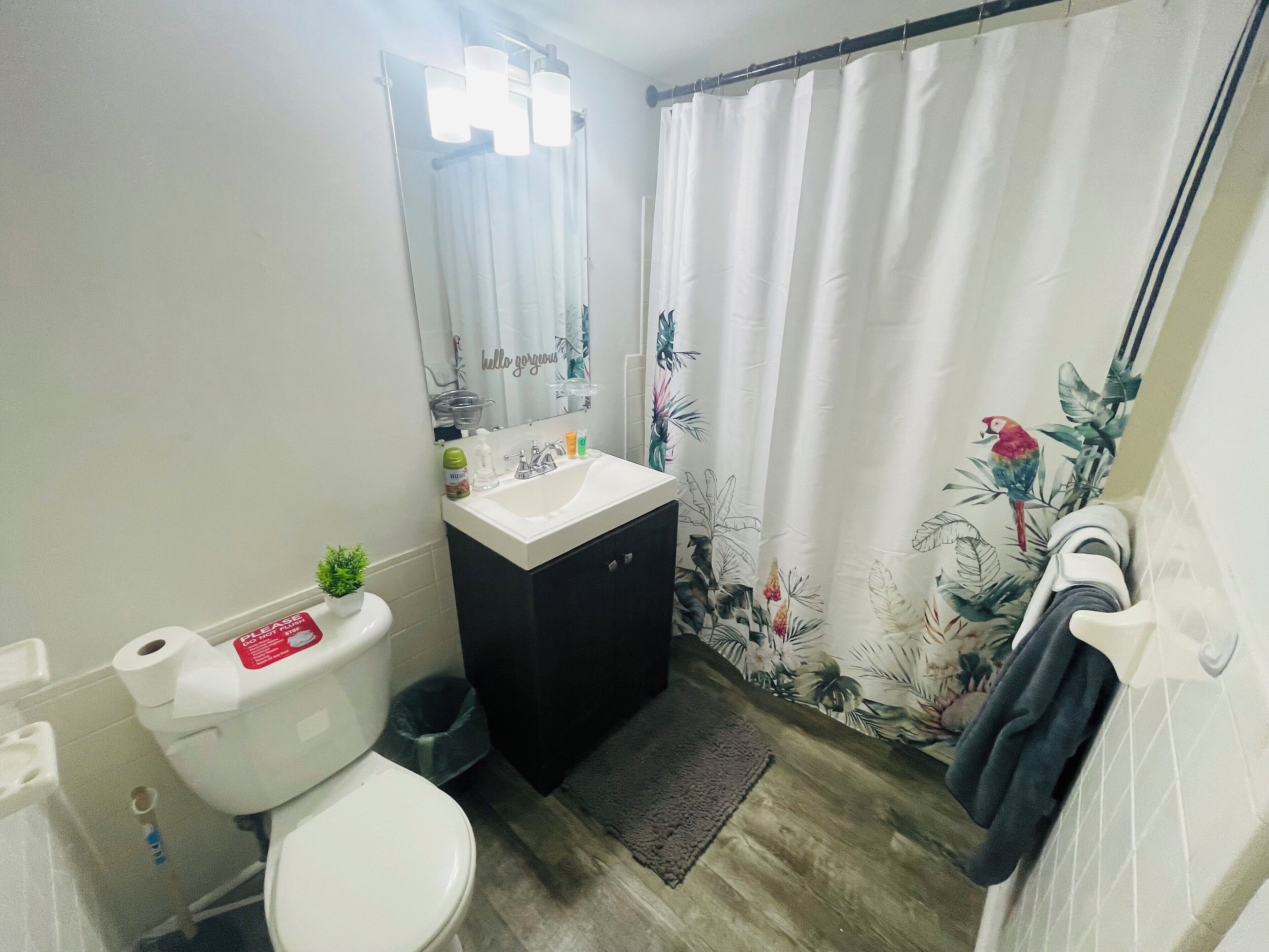 A bathroom with a toilet, sink, and shower curtain.