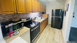 Une cuisine avec des meubles de rangement en bois, un réfrigérateur en acier inoxydable, un four à micro-ondes et une cuisinière.