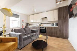 A modern living room with a sofa, coffee table, and lamp.