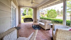 A covered porch with wicker furniture, a ceiling fan, and a view of a residential area. - Spacious & Private Augusta Getaway Near Downtown! (Augusta)