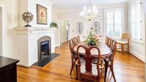 A dining room with a fireplace, wooden dining table, and chairs. - Spacious & Private Augusta Getaway Near Downtown! (Augusta)