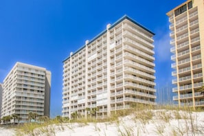 Un hôtel situé en bord de mer, avec plusieurs étages, des balcons et une vue dégagée sur la plage.