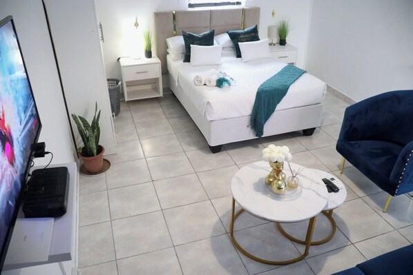 Relax in a serene space with a comfortable bed, a cozy reading nook, and a stylish coffee table.