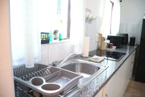 Enjoy cooking in this well-equipped kitchen with a grater, stainless steel sink, and induction cooktop.