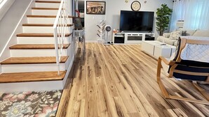 A staircase with wooden steps and white railings, a flat-screen TV, a sofa, a plant, and a clock on the wall. - Sherizee Home close to beach and 3 miles to Salem's Haunted happenings (Marblehead)