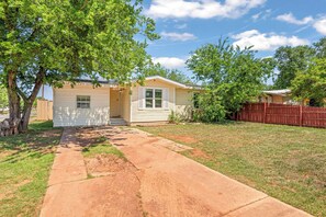 A single-story house with a front porch, a small yard, and a wooden fence. - Near HSU, ACU & Hendrick ~ Clean ~ Charming Cottage ~ New Discounts ~ Dogs (Abilene)