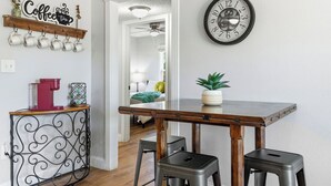 A kitchen with a coffee sign, a clock, and a potted plant on the counter. - Near HSU, ACU & Hendrick ~ Clean ~ Charming Cottage  ~ New Discounts ~ Dogs (Abilene)
