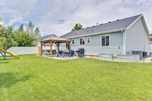 A single-story house with a covered patio, a play area, and a backyard. - Timp Retreat | EV | Free Massage* | Backyard (Orem)