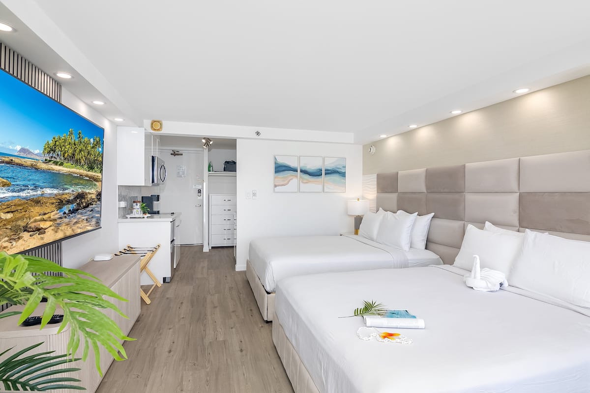 Ein modernes Hotelzimmer mit zwei Betten, einem Schreibtisch und Meerblick.