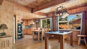 A wooden interior with a pool table, dining area, and kitchen. - Hidden Pines - Hot Tub, BBQ & Pool Table (Big Bear Lake)