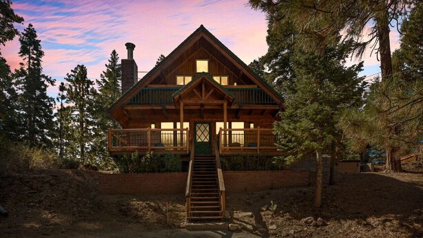 A log cabin with a balcony, a chimney, and a staircase leading to the entrance. - Hidden Pines - Hot Tub, BBQ & Pool Table (Big Bear Lake)