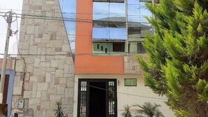 A modern building with a stone facade, large reflective windows, and a flat roof. - kallma adventures (Ica)