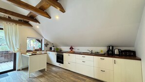 Une cuisine moderne avec des armoires blanches, un plan de travail en bois et un four encastré.