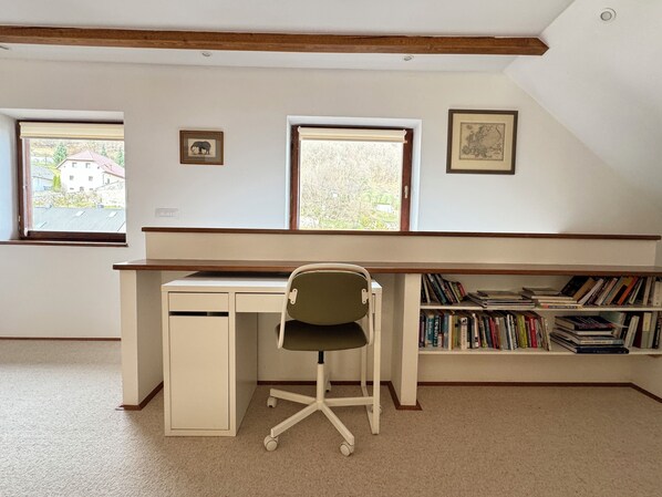A study room with a desk, chair, and bookshelves.