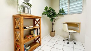 A room with a wooden bookshelf, a desk with a chair, and two potted plants. - Jetsetter's Retreat (Carolina)