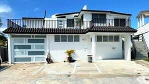 A two-story house with a garage, a balcony, and a small garden area. - Jetsetter's Retreat (Carolina)