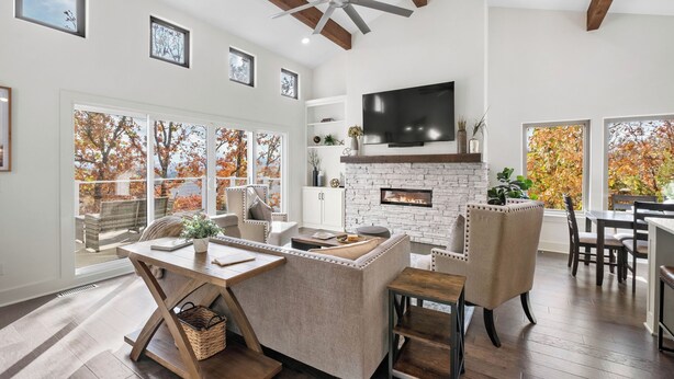 A spacious living room with a fireplace, a large TV, and a dining area.
