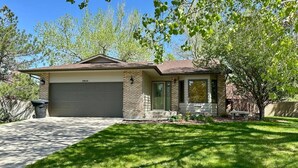 A single-story house with a garage, a front porch, and a well-maintained lawn. - Modern Comforts - Stay/Work/Play (Casper)