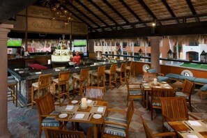 A restaurant with wooden furniture, a bar area, and a view of the outside.