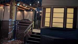 Eine Hütte mit einer Veranda, einer Treppe und Lichterketten.