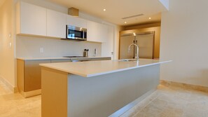 Cozinha moderna com ilha central, eletrodomésticos em aço inoxidável e design minimalista.