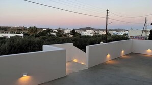 A rooftop terrace with white walls and small lights along the edges. - Aristotle Suites, Aegle
 (Adamantas)