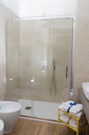 Habitación Deluxe | Baño | Ducha, artículos de higiene personal gratuitos y secador de pelo