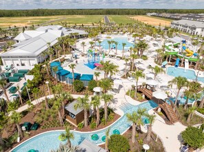 A resort with multiple swimming pools, water slides, and palm trees.