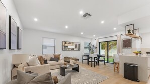 A modern living room with a sofa, coffee table, and dining area. - Casa Calma
2 min to Famous Atlantic Ave, Pool coming Oct 2025 (Delray Beach)