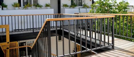 A modern building with a wooden deck and a metal railing.