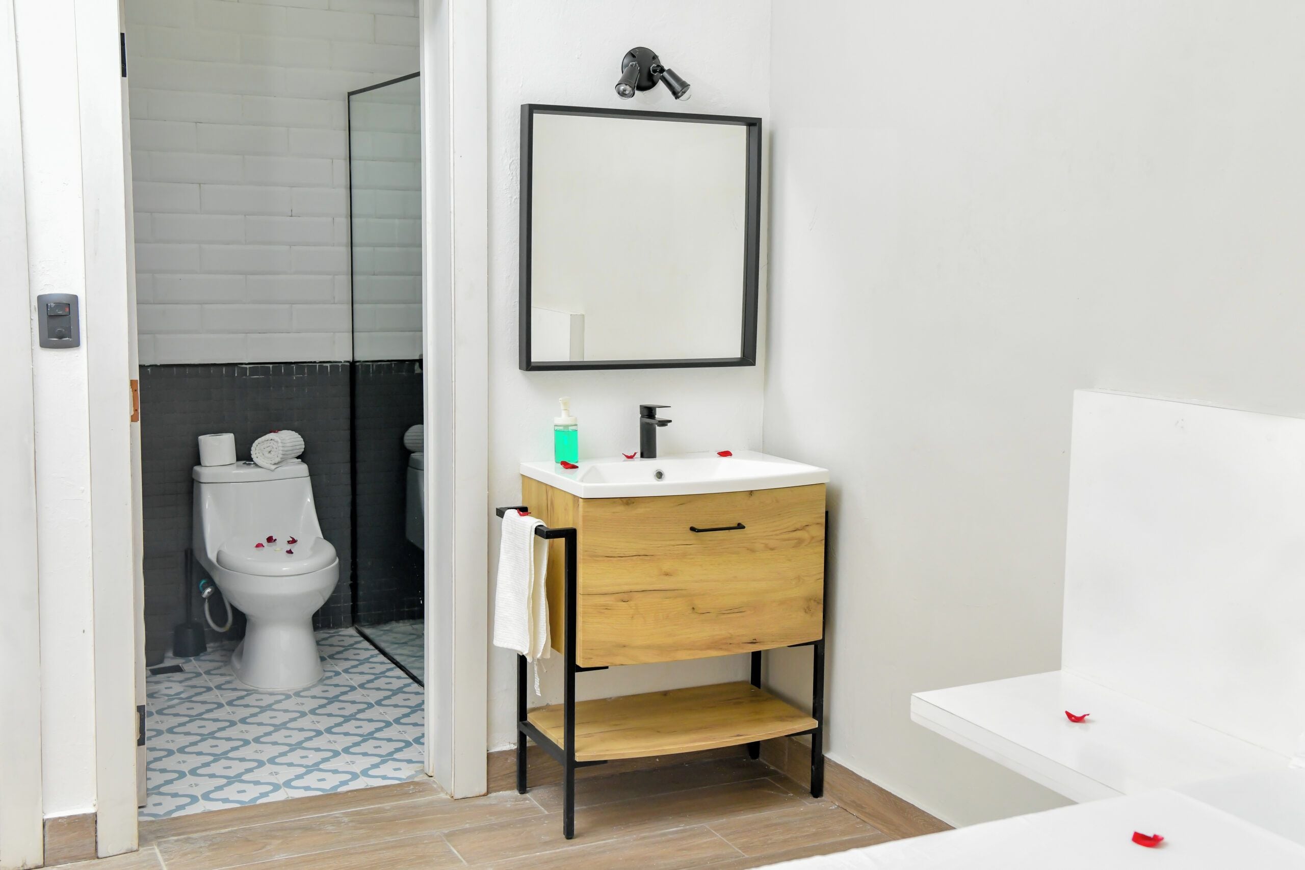 A bathroom with a white sink, a mirror, and a toilet.