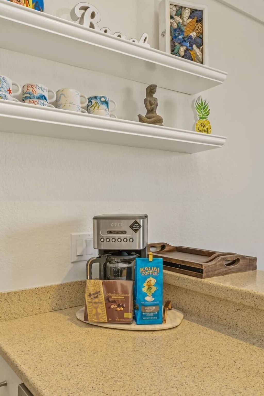 A kitchen counter with a coffee maker, a bag of coffee, and a box of coffee pods.