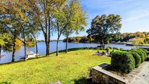 A lakeside view with a grassy area, trees, and a dock. - Lakefront Lake Anna - Views, Boat Dock, Games (Mineral)