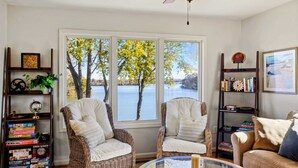 A living room with wicker chairs, a glass coffee table, and bookshelves. - Lakefront Lake Anna - Views, Boat Dock, Games (Mineral)