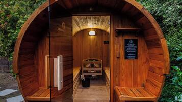 Relax in this sauna with a bench, table, and bucket.