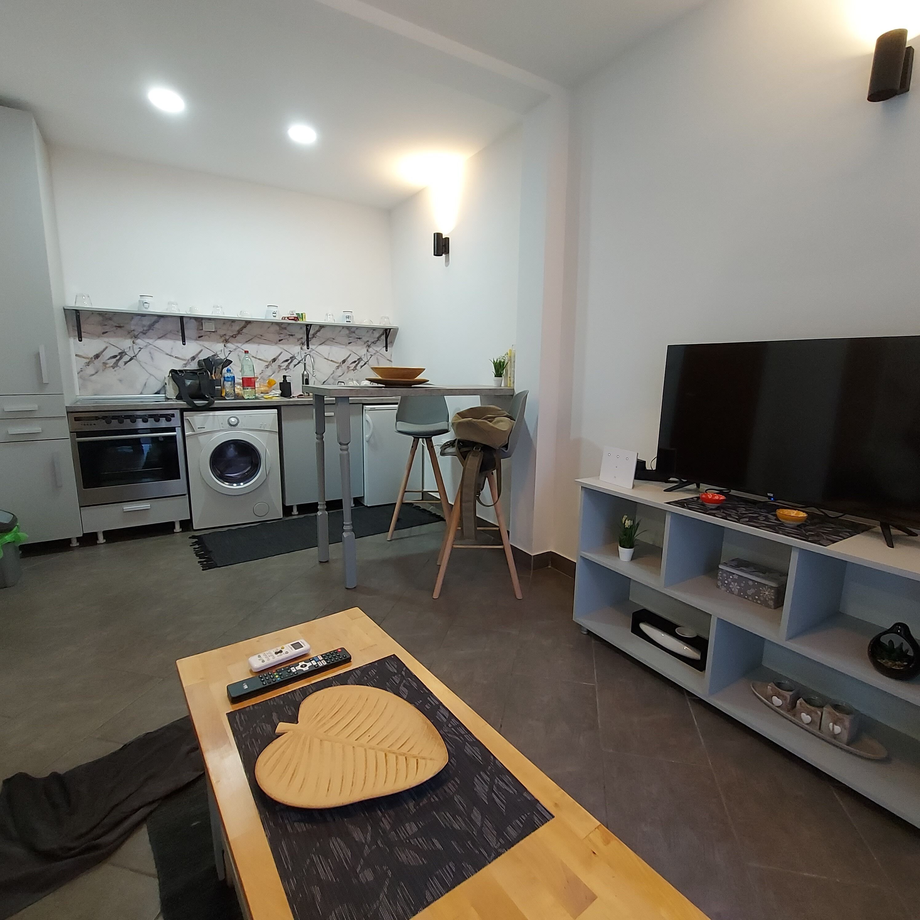A modern kitchen with a marble backsplash, a built-in oven, and a washing machine.