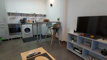 A modern kitchen with a marble backsplash, a built-in oven, and a washing machine.