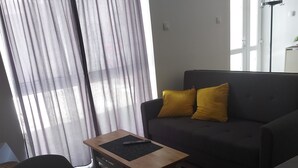 A living room with a sofa, a small wooden table, and a chair. - Hidden place in pedestrian zone (Novi Sad)
